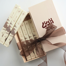 Set of Lush products in a box with a brown ribbon on a light background